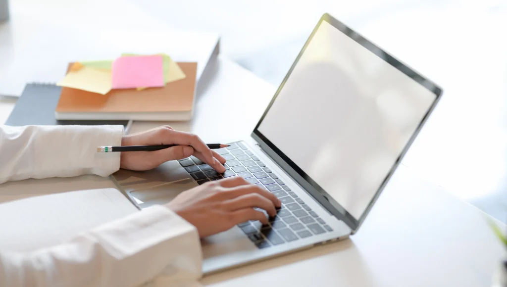 Isparta'da web tasarım hizmetlerini temsil eden laptop ve kitaplarla donatılmış modern bir masa.