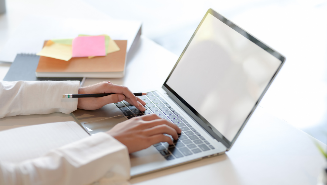 Isparta'da web tasarım hizmetlerini temsil eden laptop ve kitaplarla donatılmış modern bir masa.